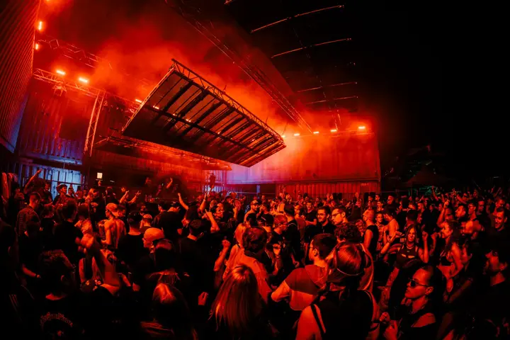 Rote Container-Halle mit LED-Panel über der Menge